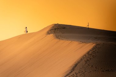 Vietnam 'ın Ninh Thuan eyaletinde, kum tepecikleri arasında giyinmiş Vietnamlı bir kadının hava görüntüsü. Vietnam 'da seyahat ve fotoğraf için en güzel yerlerden biridir.