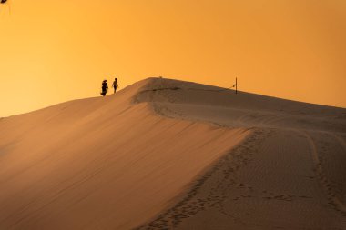 Köylü bir kadının havadan görünüşü, Vietnam 'ın Ninh Thuan eyaletinde kum tepeleri üzerinde bambu bir çerçeve taşır. Vietnam 'da seyahat ve fotoğraf için en güzel yerlerden biridir.