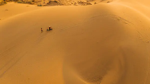 stock image Aerial view of a peasant woman carries a bamboo frame on the shoulder across sand dunes in Ninh Thuan province, Vietnam. It is one of the most beautiful places in Vietnam for travel and photography