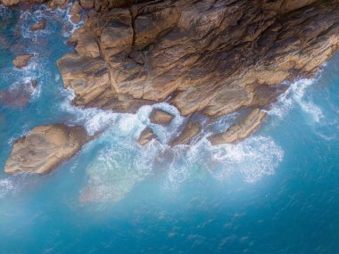 Kayalık ada kıyısına düşen güzel dalgaların, okyanus dalgalarının ve fantastik dalgaların hava aracı görüntüsü. Vietnam 'da okyanus. Seyahat ve deniz manzarası
