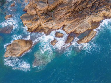 Kayalık ada kıyısına düşen güzel dalgaların, okyanus dalgalarının ve fantastik dalgaların hava aracı görüntüsü. Vietnam 'da okyanus. Seyahat ve deniz manzarası