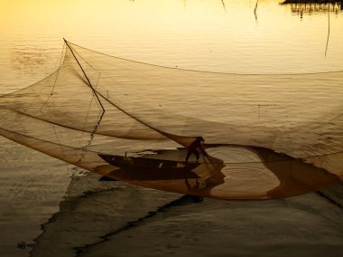 Kimliği belirlenemeyen balıkçı, ağlarını Hoi Nehri 'nde kontrol ediyor. Antik bir kasaba, Quang Nam Vilayeti, Vietnam. Hoi An, Vietnam 'daki en popüler yerlerden biridir. Seyahat kavramı