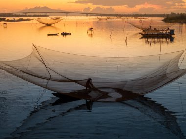 Kimliği belirlenemeyen balıkçı, ağlarını Hoi Nehri 'nde kontrol ediyor. Antik bir kasaba, Quang Nam Vilayeti, Vietnam. Hoi An, Vietnam 'daki en popüler yerlerden biridir. Seyahat kavramı