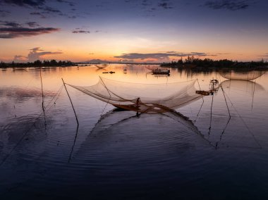 Kimliği belirlenemeyen balıkçı, ağlarını Hoi Nehri 'nde kontrol ediyor. Antik bir kasaba, Quang Nam Vilayeti, Vietnam. Hoi An, Vietnam 'daki en popüler yerlerden biridir. Seyahat kavramı