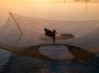 Kimliği belirlenemeyen balıkçı, ağlarını Hoi Nehri 'nde kontrol ediyor. Antik bir kasaba, Quang Nam Vilayeti, Vietnam. Hoi An, Vietnam 'daki en popüler yerlerden biridir. Seyahat kavramı