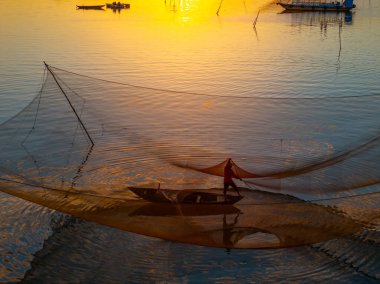 Kimliği belirlenemeyen balıkçı, ağlarını Hoi Nehri 'nde kontrol ediyor. Antik bir kasaba, Quang Nam Vilayeti, Vietnam. Hoi An, Vietnam 'daki en popüler yerlerden biridir. Seyahat kavramı