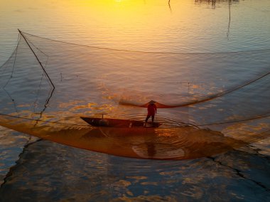 Kimliği belirlenemeyen balıkçı, ağlarını Hoi Nehri 'nde kontrol ediyor. Antik bir kasaba, Quang Nam Vilayeti, Vietnam. Hoi An, Vietnam 'daki en popüler yerlerden biridir. Seyahat kavramı