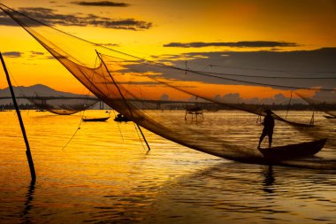 Kimliği belirlenemeyen balıkçı, ağlarını Hoi Nehri 'nde kontrol ediyor. Antik bir kasaba, Quang Nam Vilayeti, Vietnam. Hoi An, Vietnam 'daki en popüler yerlerden biridir. Seyahat kavramı