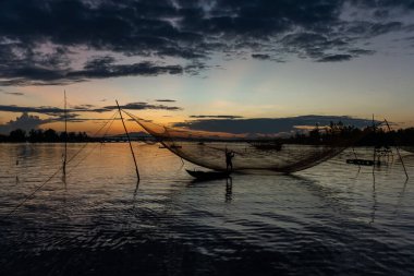 Kimliği belirlenemeyen balıkçı, ağlarını Hoi Nehri 'nde kontrol ediyor. Antik bir kasaba, Quang Nam Vilayeti, Vietnam. Hoi An, Vietnam 'daki en popüler yerlerden biridir. Seyahat kavramı