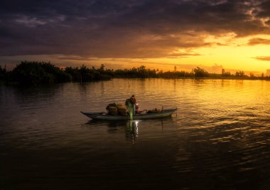 Kimliği belirlenemeyen balıkçı, ağlarını Hoi Nehri 'nde kontrol ediyor. Antik bir kasaba, Quang Nam Vilayeti, Vietnam. Hoi An, Vietnam 'daki en popüler yerlerden biridir. Seyahat kavramı