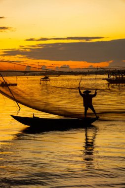 Kimliği belirlenemeyen balıkçı, ağlarını Hoi Nehri 'nde kontrol ediyor. Antik bir kasaba, Quang Nam Vilayeti, Vietnam. Hoi An, Vietnam 'daki en popüler yerlerden biridir. Seyahat kavramı