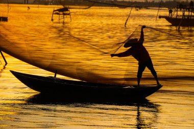 Kimliği belirlenemeyen balıkçı, ağlarını Hoi Nehri 'nde kontrol ediyor. Antik bir kasaba, Quang Nam Vilayeti, Vietnam. Hoi An, Vietnam 'daki en popüler yerlerden biridir. Seyahat kavramı