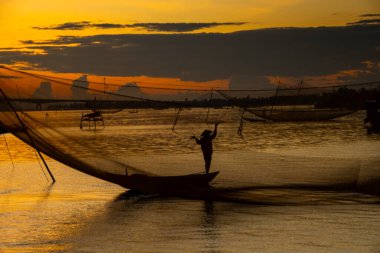 Kimliği belirlenemeyen balıkçı, ağlarını Hoi Nehri 'nde kontrol ediyor. Antik bir kasaba, Quang Nam Vilayeti, Vietnam. Hoi An, Vietnam 'daki en popüler yerlerden biridir. Seyahat kavramı