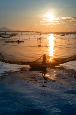 Kimliği belirlenemeyen balıkçı, ağlarını Hoi Nehri 'nde kontrol ediyor. Antik bir kasaba, Quang Nam Vilayeti, Vietnam. Hoi An, Vietnam 'daki en popüler yerlerden biridir. Seyahat kavramı