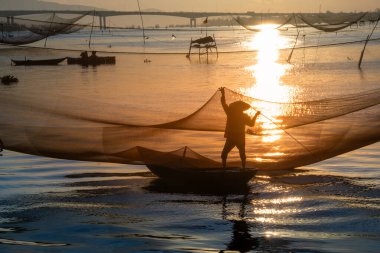 Kimliği belirlenemeyen balıkçı, ağlarını Hoi Nehri 'nde kontrol ediyor. Antik bir kasaba, Quang Nam Vilayeti, Vietnam. Hoi An, Vietnam 'daki en popüler yerlerden biridir. Seyahat kavramı