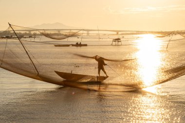 Kimliği belirlenemeyen balıkçı, ağlarını Hoi Nehri 'nde kontrol ediyor. Antik bir kasaba, Quang Nam Vilayeti, Vietnam. Hoi An, Vietnam 'daki en popüler yerlerden biridir. Seyahat kavramı