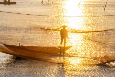 Kimliği belirlenemeyen balıkçı, ağlarını Hoi Nehri 'nde kontrol ediyor. Antik bir kasaba, Quang Nam Vilayeti, Vietnam. Hoi An, Vietnam 'daki en popüler yerlerden biridir. Seyahat kavramı