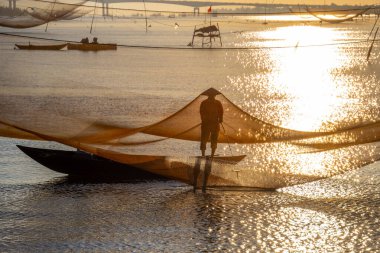 Kimliği belirlenemeyen balıkçı, ağlarını Hoi Nehri 'nde kontrol ediyor. Antik bir kasaba, Quang Nam Vilayeti, Vietnam. Hoi An, Vietnam 'daki en popüler yerlerden biridir. Seyahat kavramı