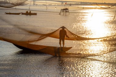 Kimliği belirlenemeyen balıkçı, ağlarını Hoi Nehri 'nde kontrol ediyor. Antik bir kasaba, Quang Nam Vilayeti, Vietnam. Hoi An, Vietnam 'daki en popüler yerlerden biridir. Seyahat kavramı