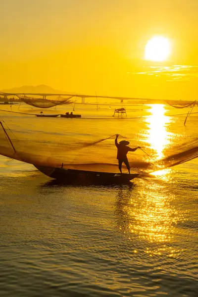 Kimliği belirlenemeyen balıkçı, ağlarını Hoi Nehri 'nde kontrol ediyor. Antik bir kasaba, Quang Nam Vilayeti, Vietnam. Hoi An, Vietnam 'daki en popüler yerlerden biridir. Seyahat kavramı