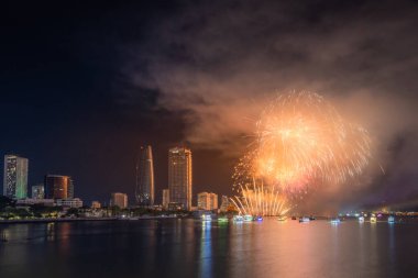 Da Nang şehri, Vietnam - 13 Temmuz 2024: Vietnam 'da Han nehri üzerinde havai fişeklerle gökyüzü aydınlandı. Güzel gece manzaralı şehir manzarası. Tatiller, yeni yılı ve Tet tatilini kutlamak.