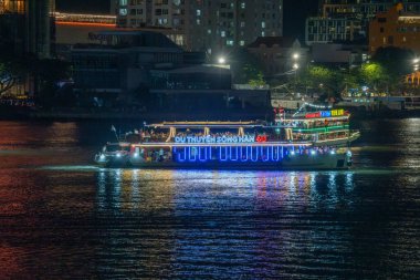 Da Nang şehri, Vietnam - 13 Temmuz 2024: Han nehri üzerinde turist botları, Da Nang şehrindeki Ejderha Köprüsü 'ne birkaç metre uzaklıkta. Seyahat ve manzara konsepti
