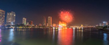 Da Nang şehri, Vietnam - 13 Temmuz 2024: Vietnam 'da Han nehri üzerinde havai fişeklerle gökyüzü aydınlandı. Güzel gece manzaralı şehir manzarası. Tatiller, yeni yılı ve Tet tatilini kutlamak.