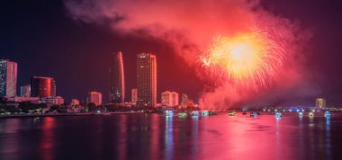 Da Nang şehri, Vietnam - 13 Temmuz 2024: Vietnam 'da Han nehri üzerinde havai fişeklerle gökyüzü aydınlandı. Güzel gece manzaralı şehir manzarası. Tatiller, yeni yılı ve Tet tatilini kutlamak.