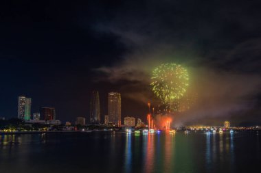 Da Nang şehri, Vietnam - 13 Temmuz 2024: Vietnam 'da Han nehri üzerinde havai fişeklerle gökyüzü aydınlandı. Güzel gece manzaralı şehir manzarası. Tatiller, yeni yılı ve Tet tatilini kutlamak.