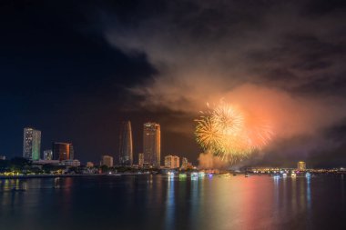 Da Nang şehri, Vietnam - 13 Temmuz 2024: Vietnam 'da Han nehri üzerinde havai fişeklerle gökyüzü aydınlandı. Güzel gece manzaralı şehir manzarası. Tatiller, yeni yılı ve Tet tatilini kutlamak.