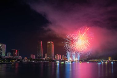 Da Nang şehri, Vietnam - 13 Temmuz 2024: Vietnam 'da Han nehri üzerinde havai fişeklerle gökyüzü aydınlandı. Güzel gece manzaralı şehir manzarası. Tatiller, yeni yılı ve Tet tatilini kutlamak.