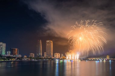 Da Nang şehri, Vietnam - 13 Temmuz 2024: Vietnam 'da Han nehri üzerinde havai fişeklerle gökyüzü aydınlandı. Güzel gece manzaralı şehir manzarası. Tatiller, yeni yılı ve Tet tatilini kutlamak.