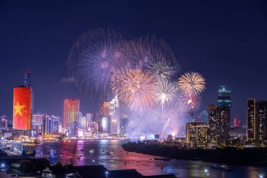Kutlama. Vietnam 'ın Ho Chi Minh şehrinde (Saigon) havai fişeklerle gökyüzü aydınlandı. Güzel gece manzaralı şehir manzarası. Tatiller, yeni yılı ve Tet tatilini kutlamak.