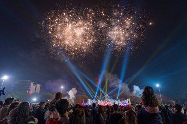 Pleiku şehri, Vietnam - 9 Şubat 2024: Yeni Yıl - İnsanlar gece gökyüzündeki güzel renkli havai fişekleri ve ışıkları izleyip Vietnam Bayrağı ve Ho Chi Minh heykelini kutluyorlar.