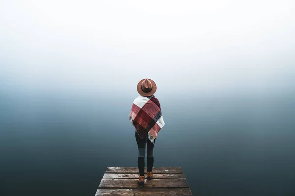 Young Woman Wearing Hat Mountain Clothes Standing Alone Pier Looking lizenzfreie Stockbilder