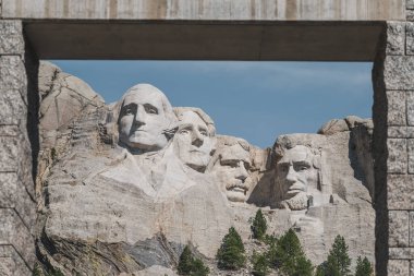 Bir kemerli çerçeve dağı. Rushmore, dağ yamacına oyulmuş dört ünlü Amerikan başkanının yüzünü sunar.