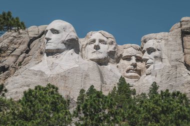 Dağın yakın görüntüsü. Rushmore, dağ yamacına oyulmuş dört ünlü Amerikan başkanının yüzünü sunar.