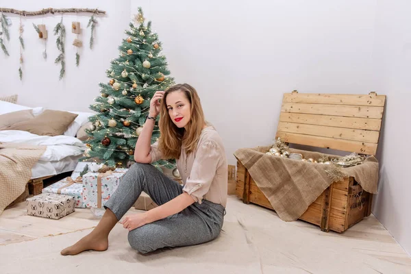 Stylová Moderní Tisíciletá Žena Sedí Poblíž Umělého Vánočního Stromku Dřevěné — Stock fotografie