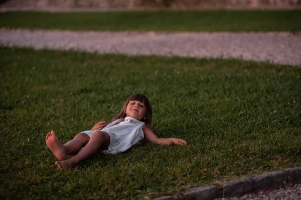 Little Girl White Sundress Lies Green Lawn Child Have Fun — Photo