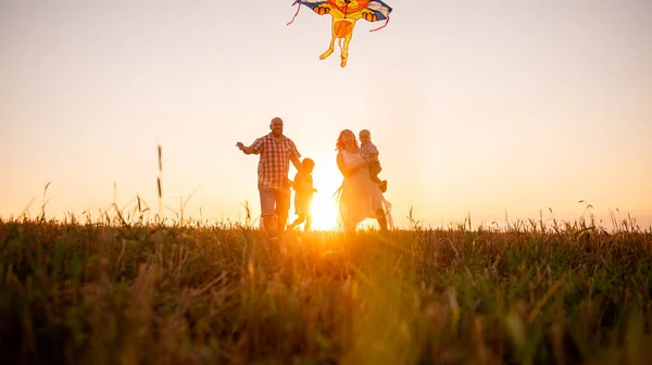 Gün Batımında Gökyüzünde Uçurtmayla Koşan Ailenin Panoramik Çeşitlilik Görüntüsü Kulağının — Stok fotoğraf