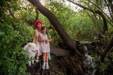 Yeşil Orman 'da, küçük bir çeşitlilik deresinde, pembe saçlı anne kızını kucaklıyor. Beyaz kabarık tüylü samozlar aileyi koruyor. Hafta sonları evcil hayvanlarla seyahat etmek. Doğayla bütünlük kavramı