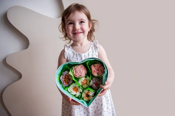 Mała Kręcona Dziewczynka Trzyma Pudełko Kształcie Serca Domowej Roboty Słodkie — Zdjęcie stockowe