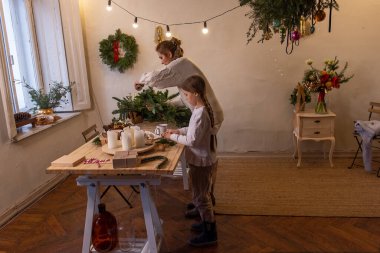 Genç anne ve küçük kızı birlikte ladin ve okaliptüs dallarından Noel çelengi yapıyorlar. Bekar anne, kızlara yeni yıl dekorasyonunun nasıl yapılacağını öğretiyor. Tatil için aile ortamı