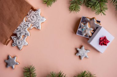 Şeftalili tüy yumağında Noel için gümüş zencefilli kurabiye şeklinde el işi çanta var. Yeşil köknar dalları, sicim, kırmızı fiyonklu beyaz hediye kutusu olan durgun yaşamın en üst görüntüsü