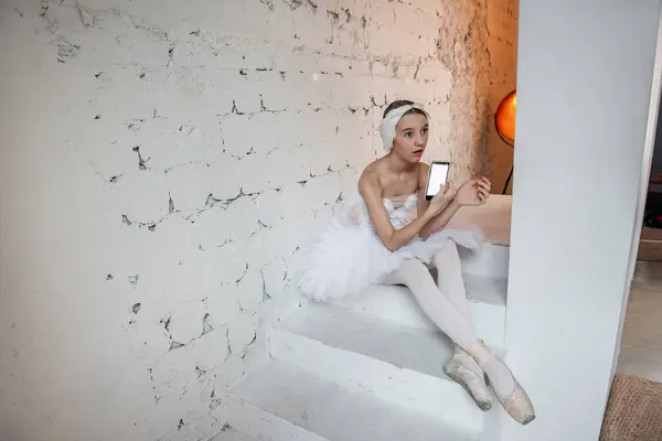 Giovane Ballerina Tutù Bianco Con Tiara Piume Siede Sui Gradini Foto Stock