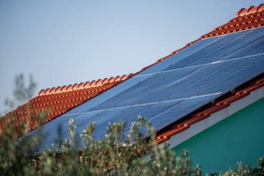 Kırmızı kiremitli evlere uydu antenli, doğal manzaralı güneş panelleri monte edildi. Temiz enerjiyi temsil ediyor, kırsal teknoloji entegrasyonu. Çatıda fotovoltaik sistem var. Hırvatistan Avrupa