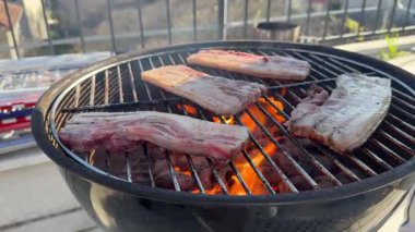 Izgarada cızırdayan leziz domuz eti, altın alevler yoğun dumanlı yumuşak et ve ağız sulandıran açık hava aroması.