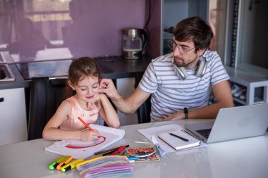 Baba evde çalışıyor. Mutfak masasında mutlu bir şekilde resim çizen küçük kızına bakarken uzaktan işleri dengeliyor. Aile bütünlüğünü somutlaştırıyor.
