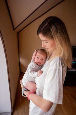 Annem yeni doğmuş bebeğini kollarına alıp sevgi ve rahatlıkla dolu sıcak bir atmosfere sararak evlerinde huzurlu ve besleyici bir an yaratıyor.