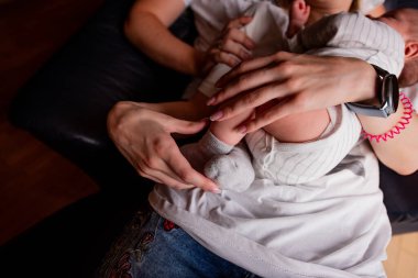 Bir ebeveynin yeni doğmuş bir bebeği kucaklarken yakaladığı sevgi dolu bir an. Kibarca kucaklaşmak, ebeveynler ve çocuklar arasındaki sıcaklığı, rahatlığı ve şefkati iletir.